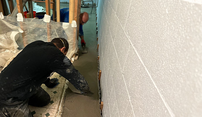 Professional workers waterproofing a basement Professional workers waterproofing a basement