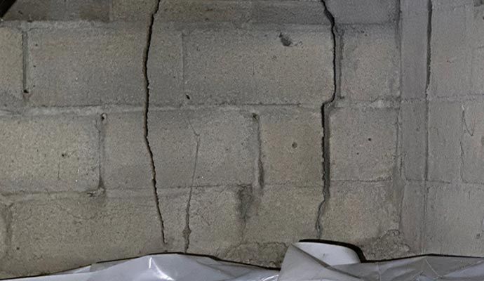 Concrete block foundation wall with a large vertical crack