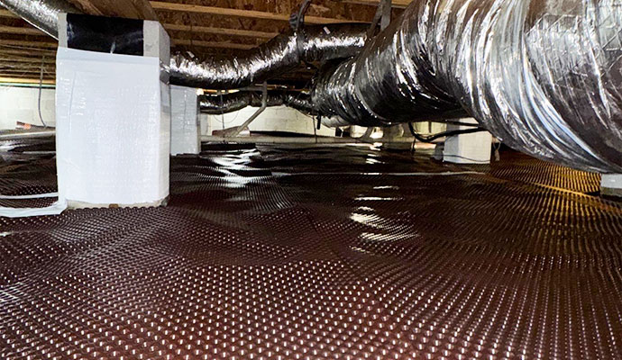 Dimpled drainage matting installed across a crawl space floor