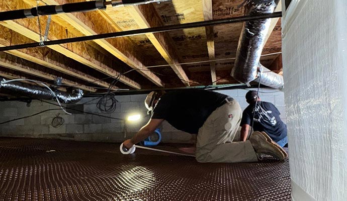 Professional team of Crawlspace Titans waterproofing a crawl-space