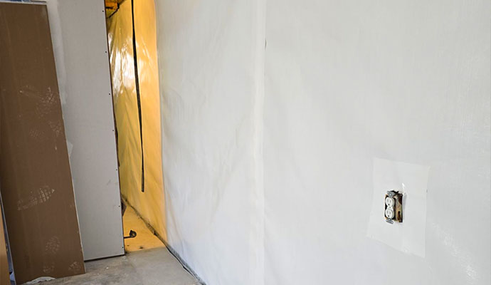 Waterproofed basement wall with vapor barrier