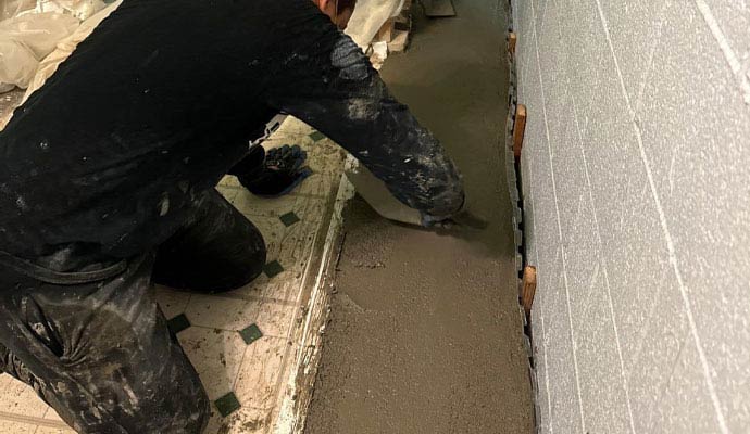 Worker installing basement drain